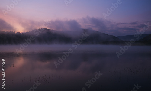 Fog at dawn over the lake in the Bieszczady Mountains