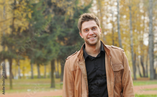 portrait of attractive happy smiling stylish young man in autumn