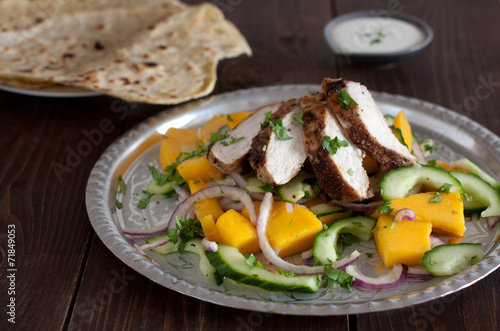Grilled chicken breast with fresh mango salad and naan bread
