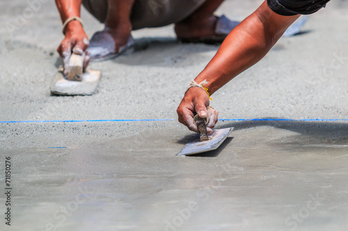 Plasterer concrete worker smooth the cement with trowel