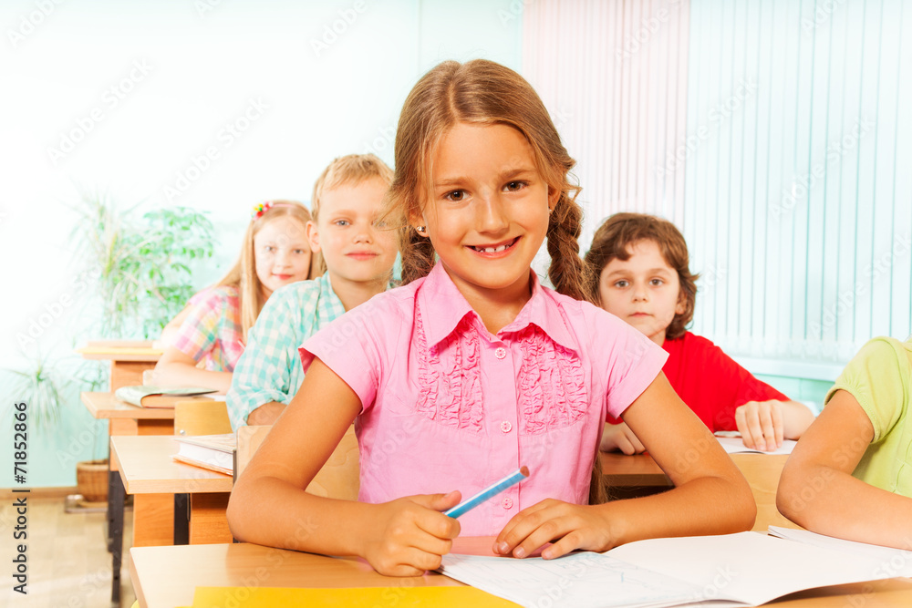 Smiling girl sitting at desk in classroom Smiling girl sitting at desk in classroom