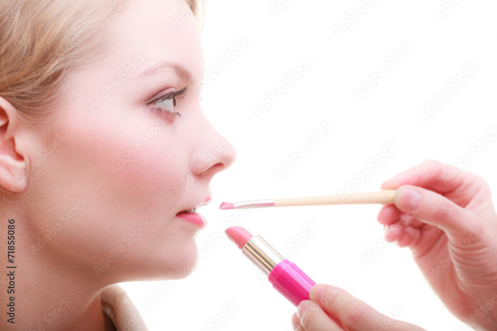 Part of face. Woman applying red lipstick with brush Part of face. Woman applying red lipstick with brush