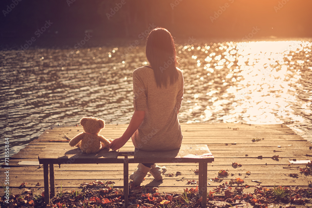 Woman and teddy bear sitting bench