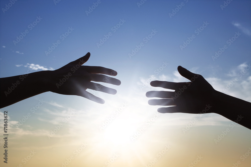 太陽の光と2人の手