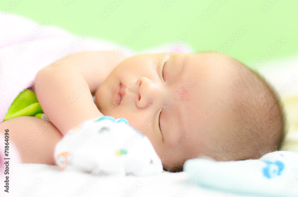 Peaceful baby lying on a bed while sleeping in a bed room Peaceful baby lying on a bed while sleeping in a bed room