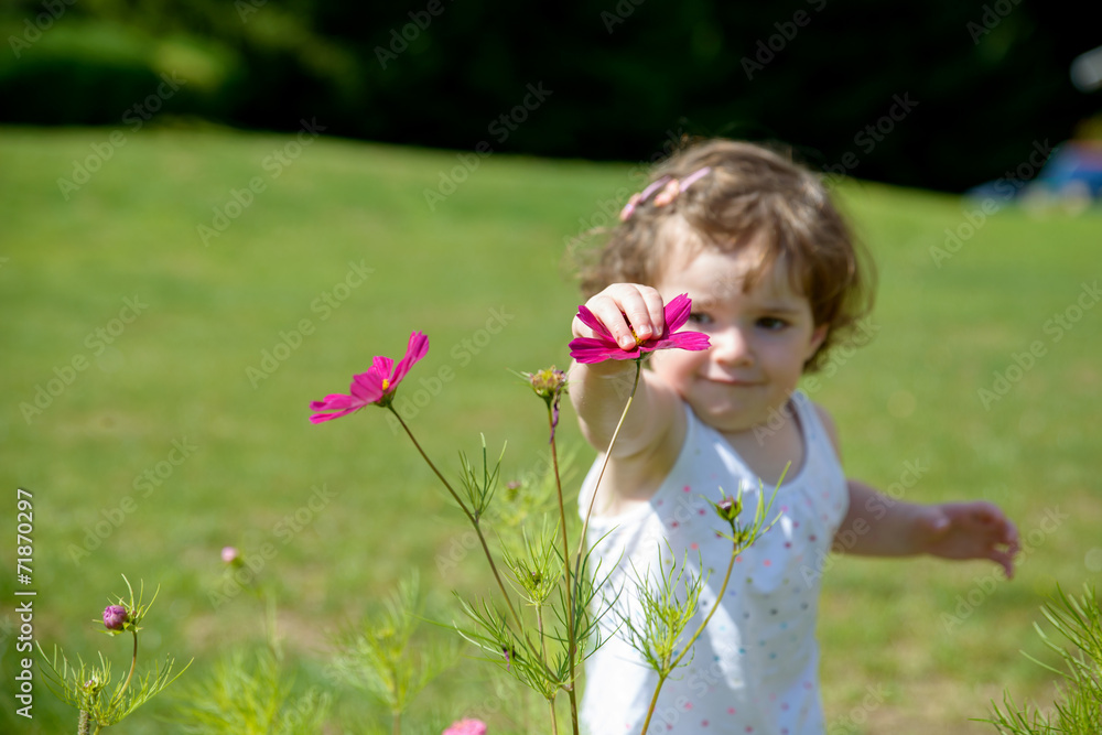 a pretty little girl playing with flowers in the garden a pretty little girl playing with flowers in the garden