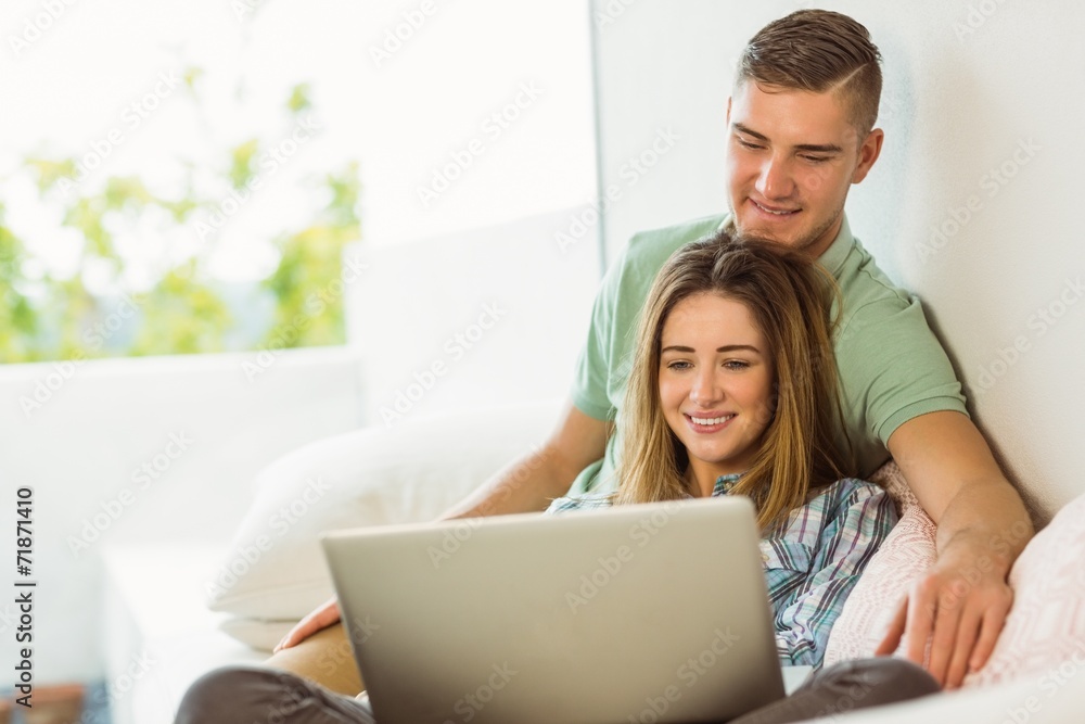 Cute couple relaxing on couch with laptop Cute couple relaxing on couch with laptop