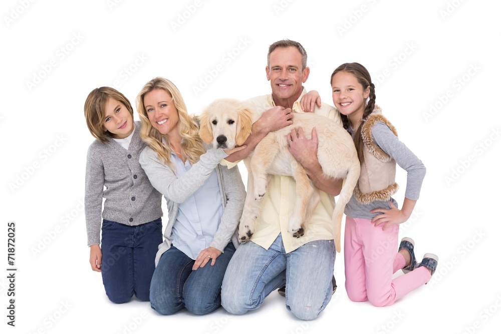 Family with their dog posing and smiling at camera together Family with their dog posing and smiling at camera together