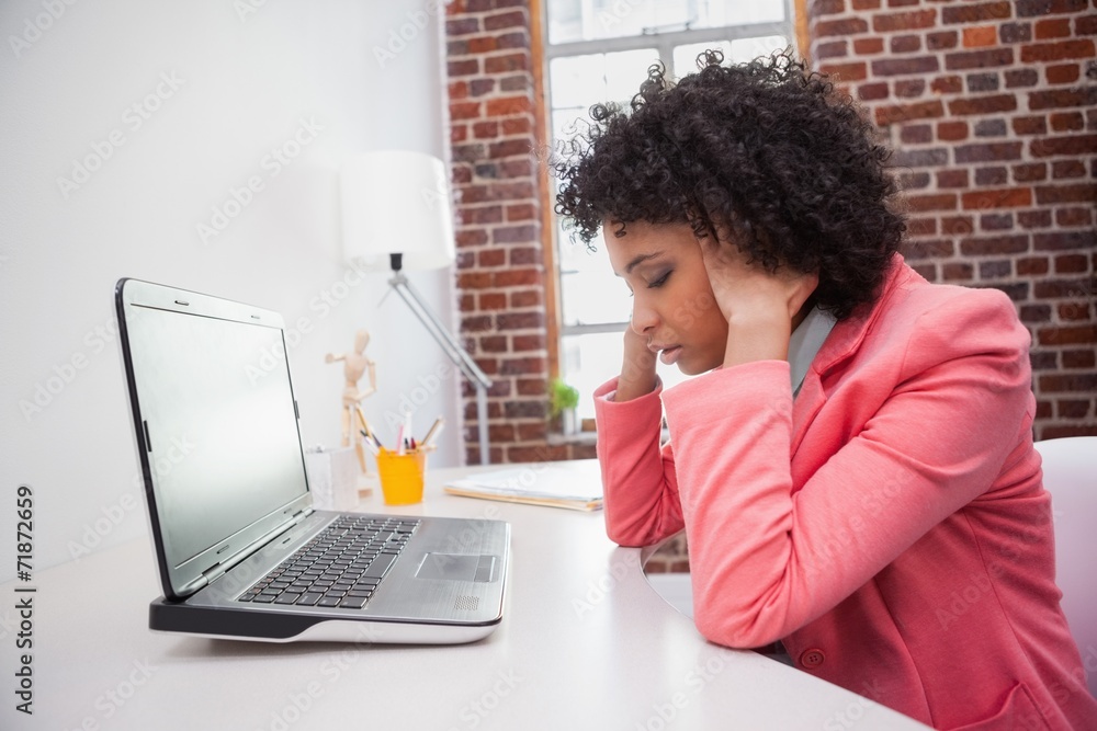 Stressed casual businesswoman sitting at desk Stressed casual businesswoman sitting at desk