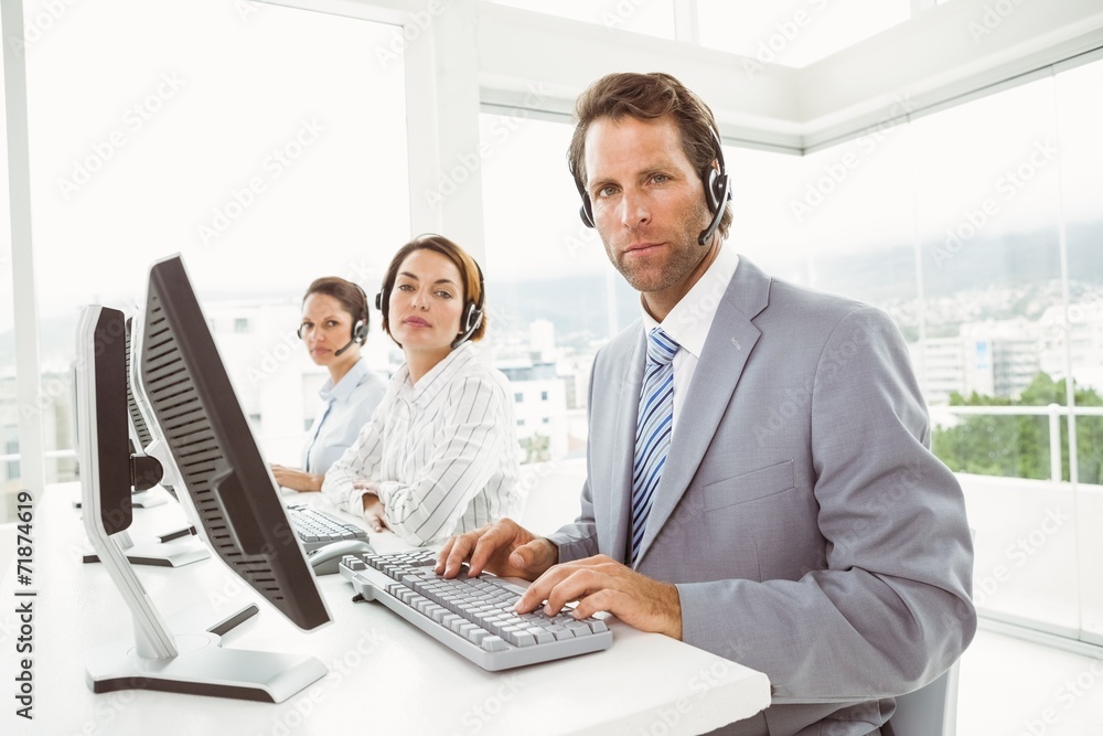 Business people with headsets using computers in office Business people with headsets using computers in office