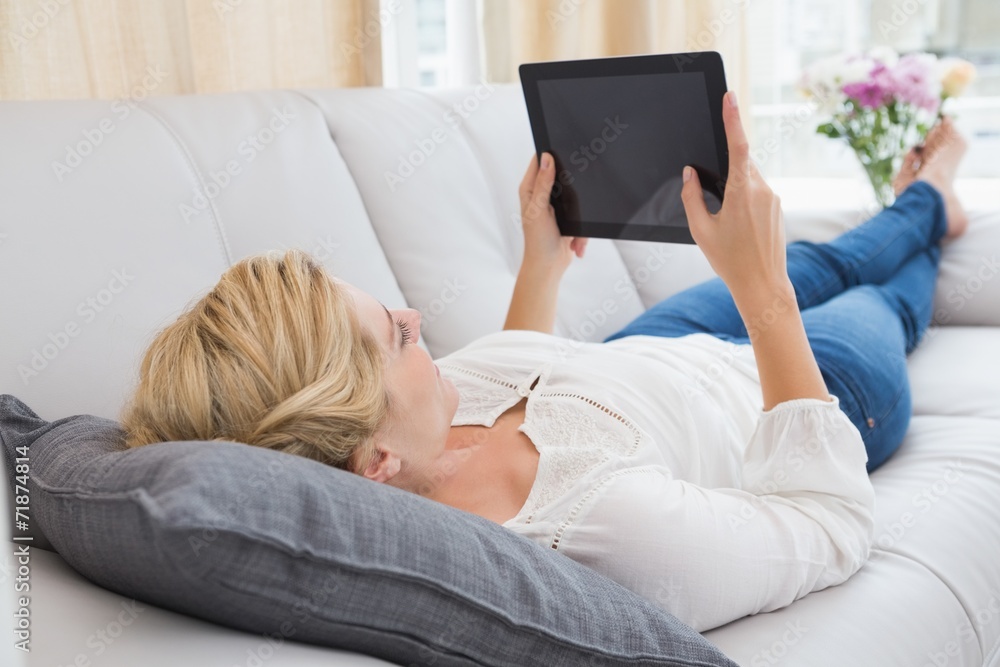 Beautiful blonde using tablet on sofa Beautiful blonde using tablet on sofa