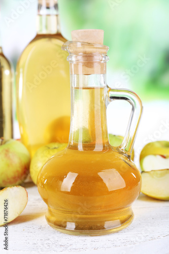 Apple cider vinegar in glass bottles and ripe fresh apples,