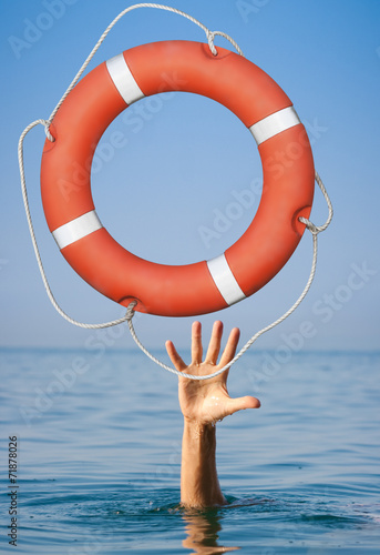 Help concept. Lifebuoy for drowning man's hand in open sea or