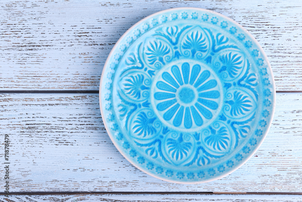 Plate on color wooden background