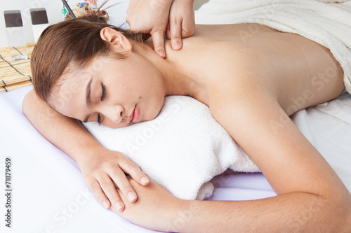 Close-up of a young woman receiving back massage at spa