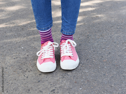 Female legs in colorful socks and sneakers outdoors