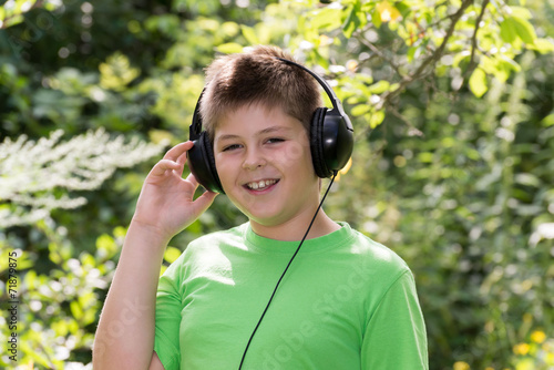 boy listening to music with headphones in  park