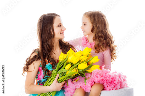 happy mother and daughter with a bouquet of yellow tulips