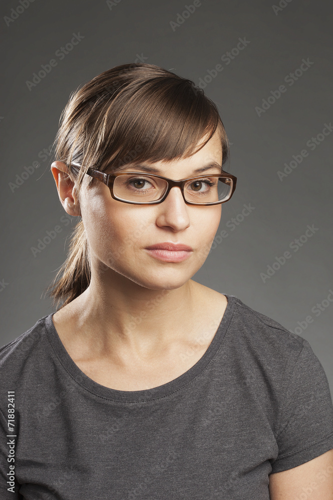 Braunhaarige Frau vor grauem Hintergrund, Portrait. Braunhaarige Frau vor grauem Hintergrund, Portrait.