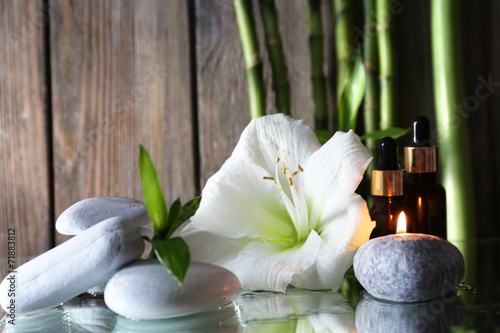 Spa set on mirror surface on wooden wall background