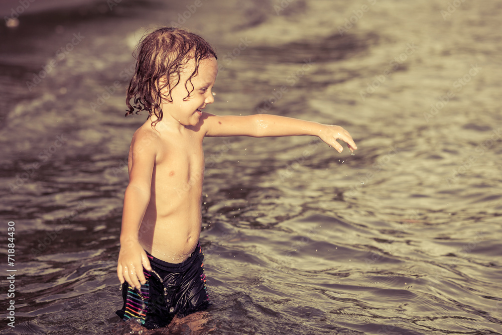 Fototapeta premium little boy playing on the beach at the day time