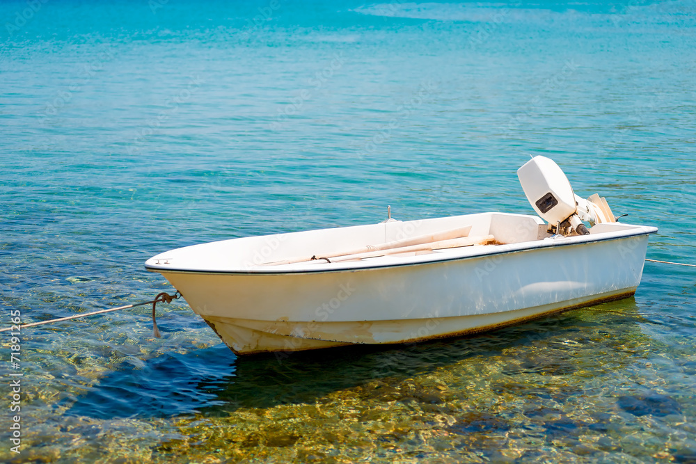 Fototapeta premium white motor boat tied to the shore