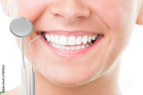 Closeup of perfect smile and dentist tools.