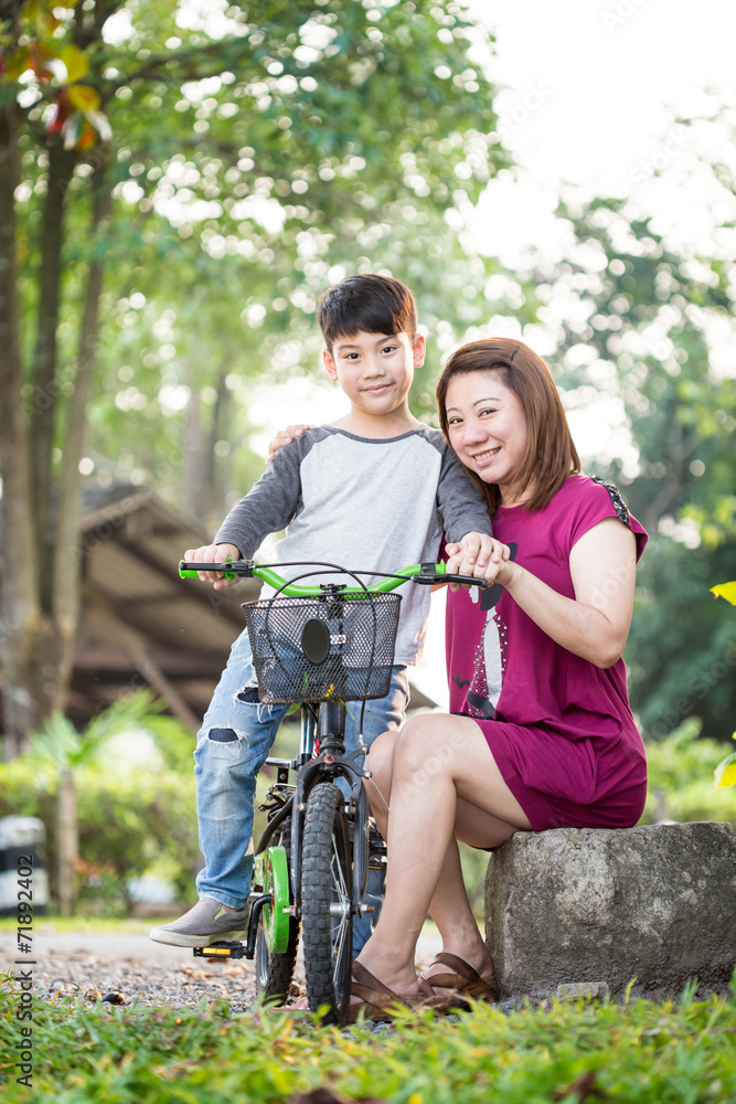little Asian child with mother practice to riding a bicycle little Asian child with mother practice to riding a bicycle