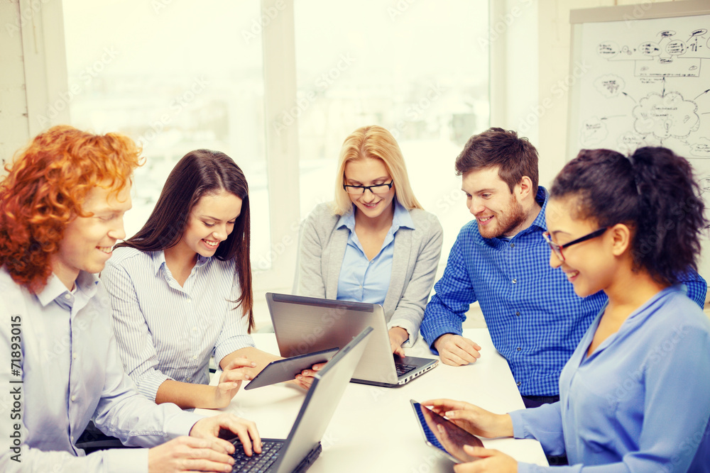 smiling team with laptop and table pc computers