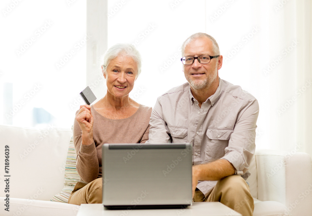 happy senior couple with laptop and credit card