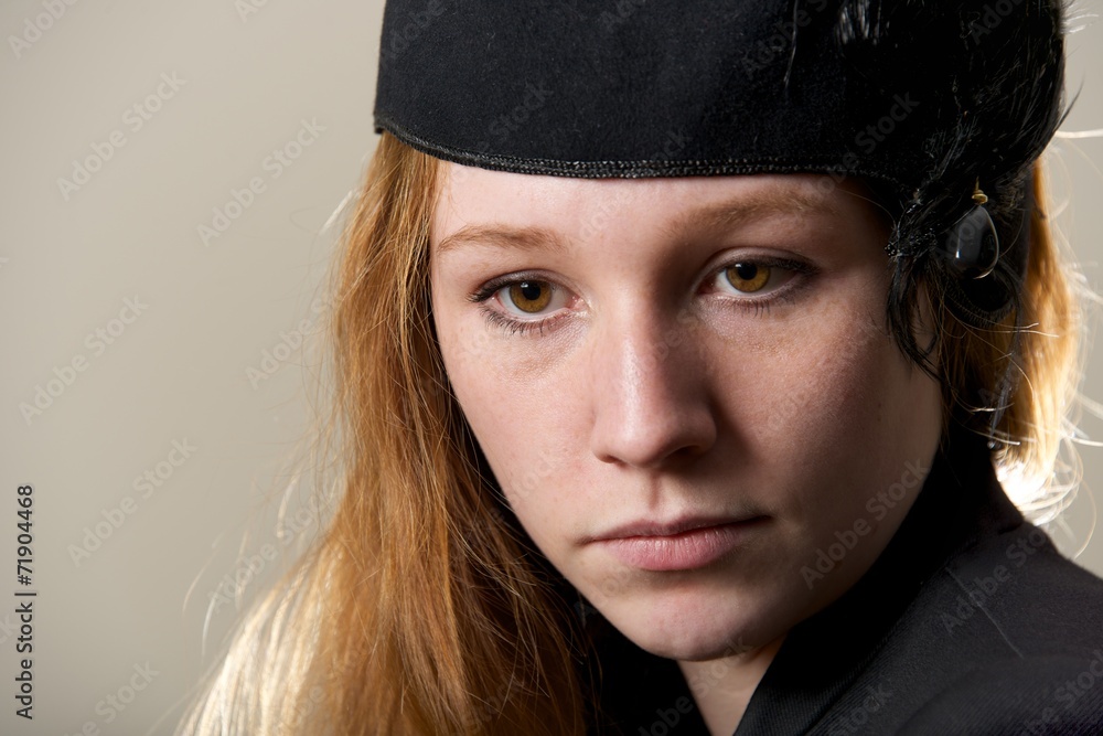 Close-up of serious redhead in black hat Close-up of serious redhead in black hat