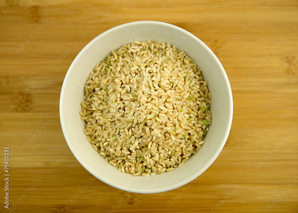 Pile of raw brown rice in a white bowl Pile of raw brown rice in a white bowl
