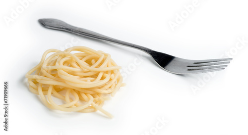 Macro of swirl of cooked spaghetti with fork isolated against wh
