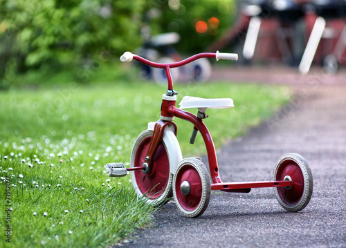 red child tricycle in a garden photo
