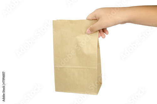 Boy holding a brown paper bag in his hand.