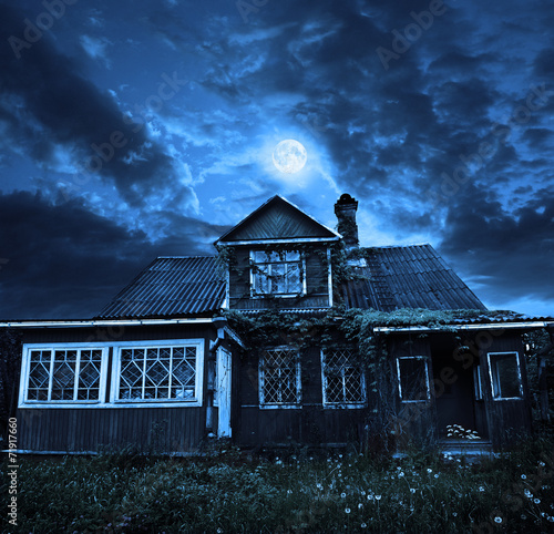 the moon in a cloudy sky, above the old wooden house
