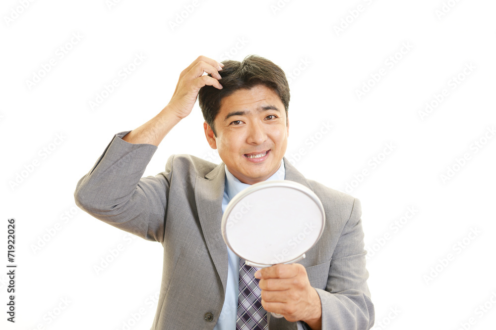 手鏡を持つ笑顔の男性