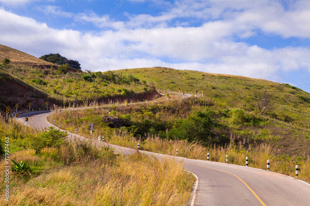 road to moutains with clouds in blue sky