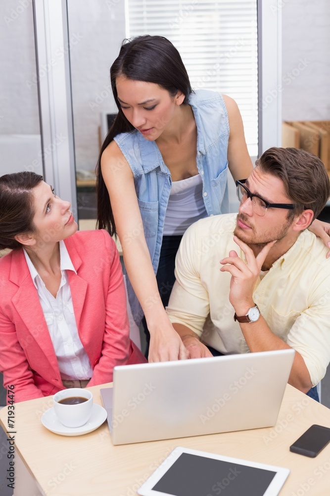 Thoughtful business team using laptop and having coffee Thoughtful business team using laptop and having coffee