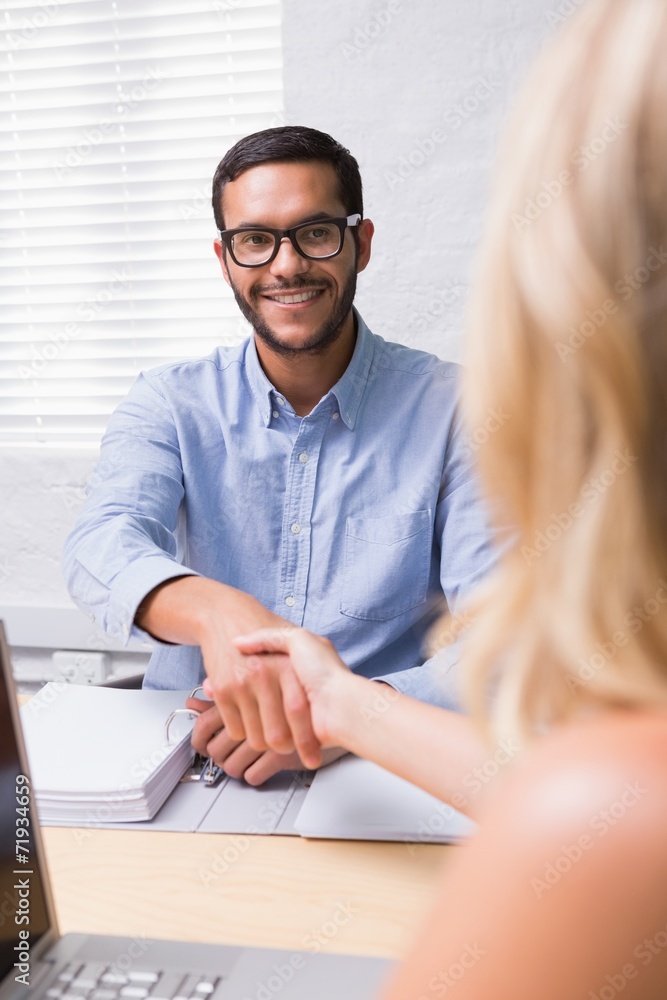 Businessman shaking hands with woman during interview Businessman shaking hands with woman during interview