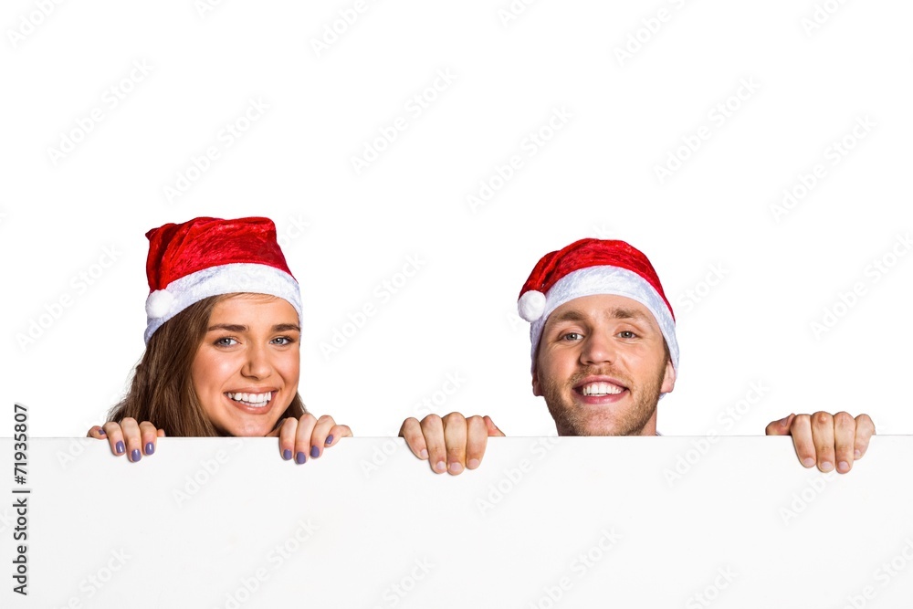 Couple in santas hats with blank board Couple in santas hats with blank board