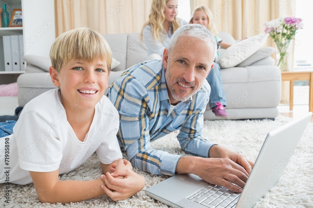 Father and son using laptop on the floor Father and son using laptop on the floor