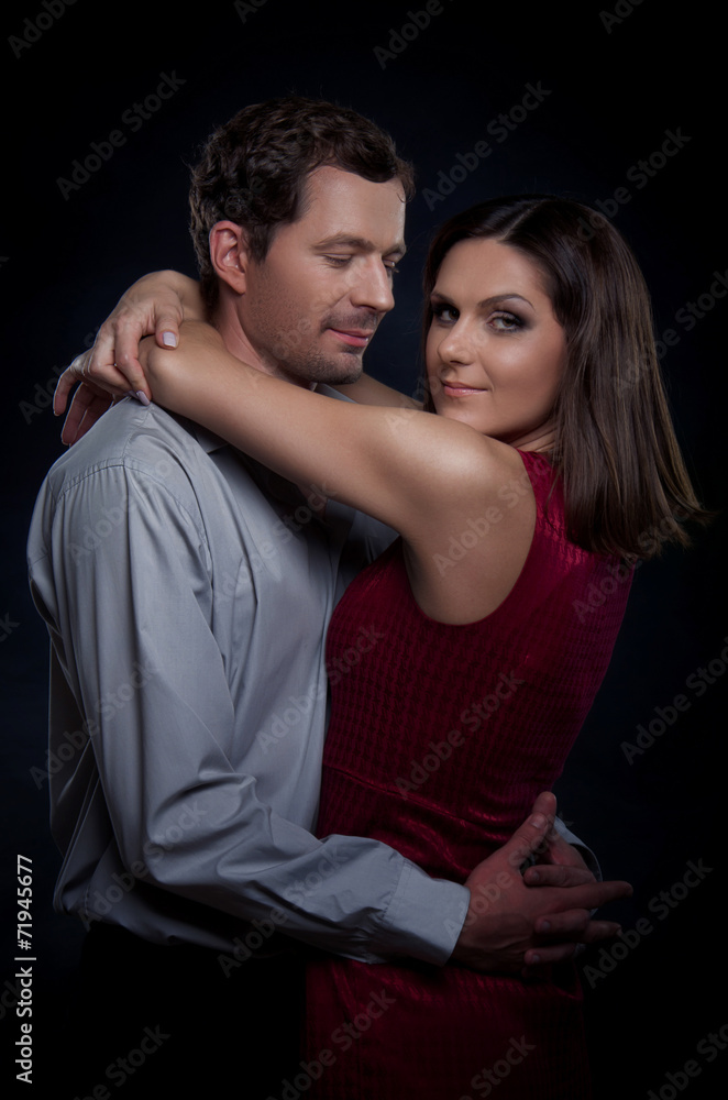 Beautiful couple in love. The woman hugs the man's neck