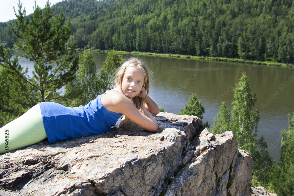 girl lying on a rock and enjoying river  view