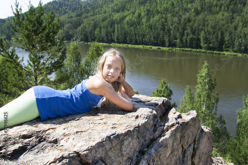 girl lying on a rock and enjoying river view