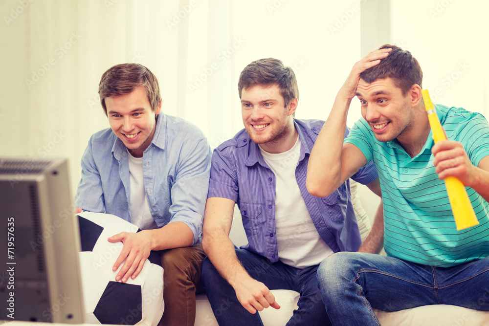 happy male friends with football and vuvuzela happy male friends with football and vuvuzela