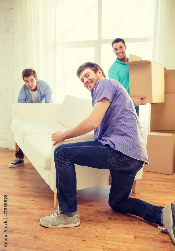 smiling friends with sofa and boxes at new home smiling friends with sofa and boxes at new home