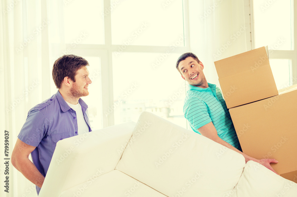 smiling friends with sofa and boxes at new home smiling friends with sofa and boxes at new home