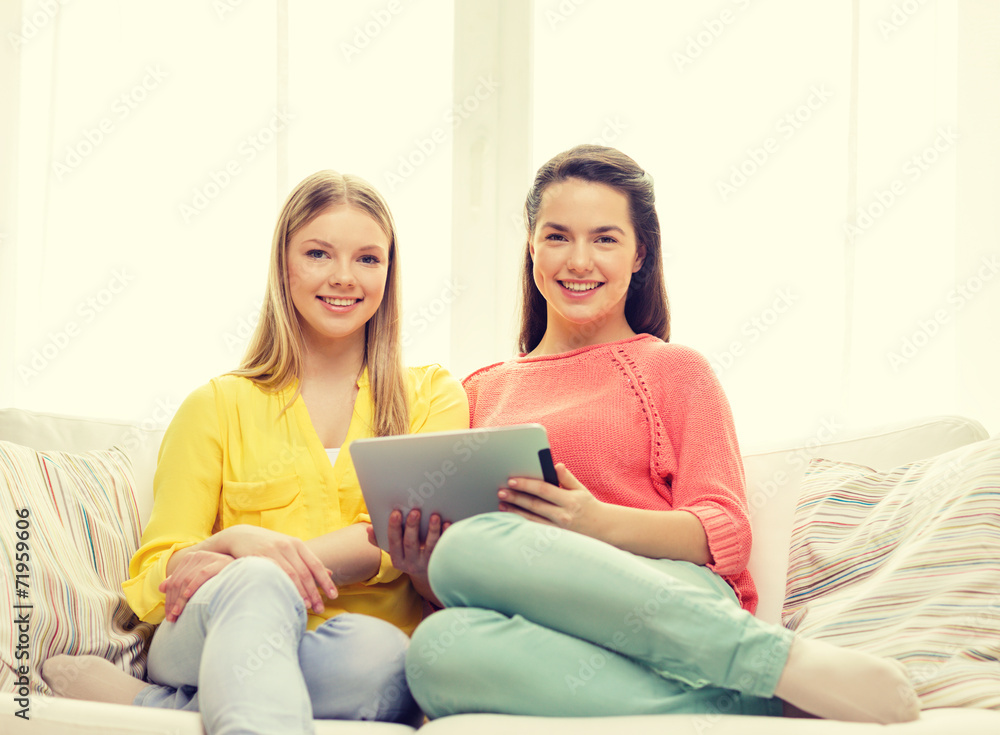 two smiling teenage girls with tablet pc at home two smiling teenage girls with tablet pc at home