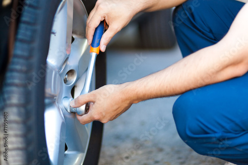Auto mechanic in his workshop changing tires or rims © Minerva Studio